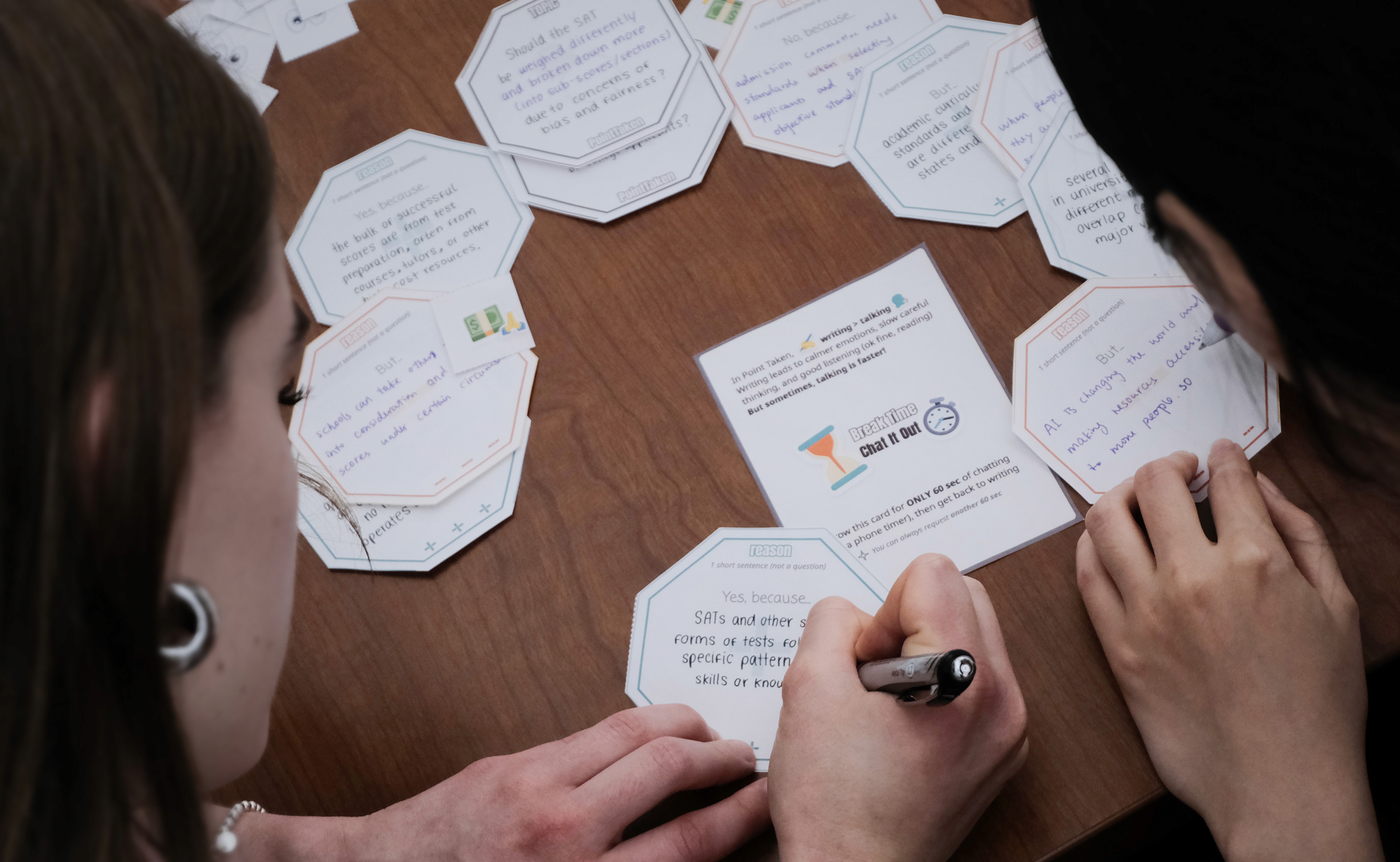Two people playing Point Taken, a game of thoughtful written debate